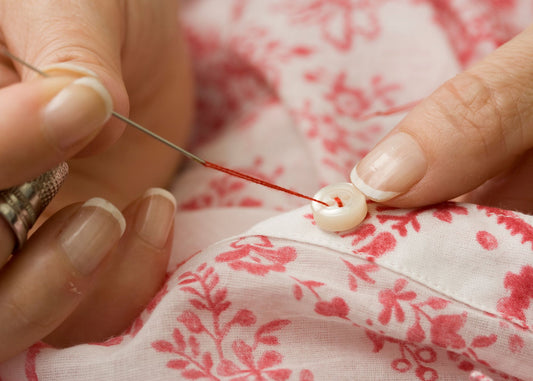 a woman sewing a button