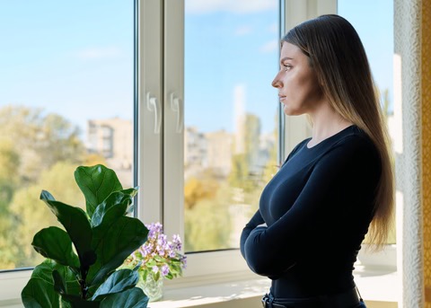 a stressed out woman staring out the window