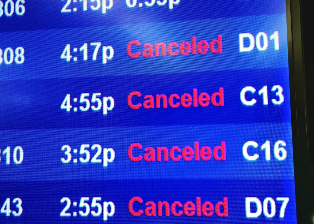A departure board at an airport showing cancelled flights.