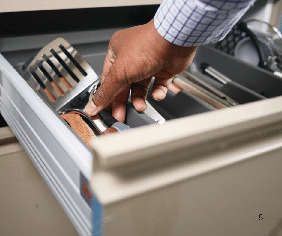 man placing a spatula in a well-organized drawer