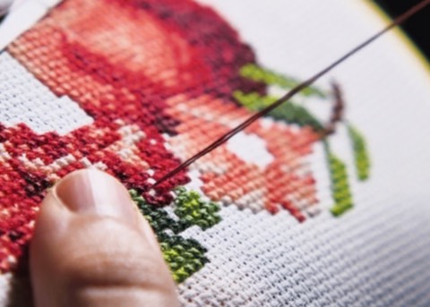 a prepared peaceful home showing a woman cross stitching