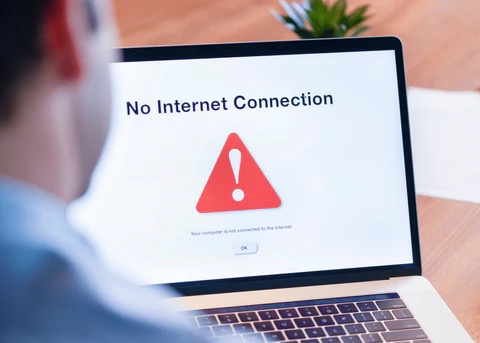 man on computer with his screen telling him he has no internet service