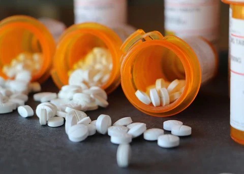 Pill bottles lying on the side with pills showing