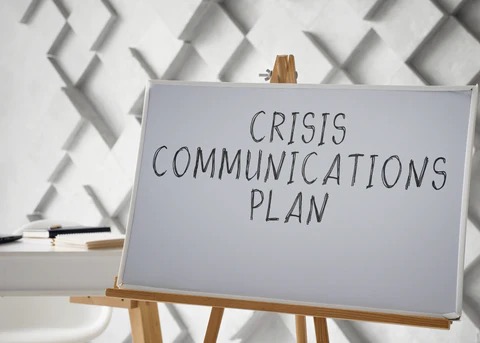 a sign on an easel that says "Crisis Communications Plan"