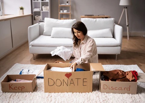 a woman sorting through items to keep, discard, or donate